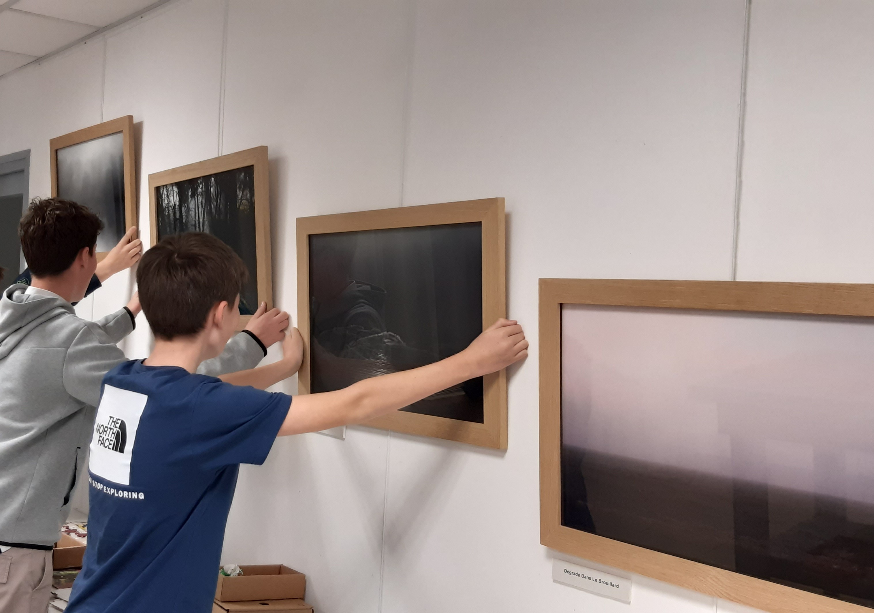 Enfants qui accrochent des tableaux sur le mur